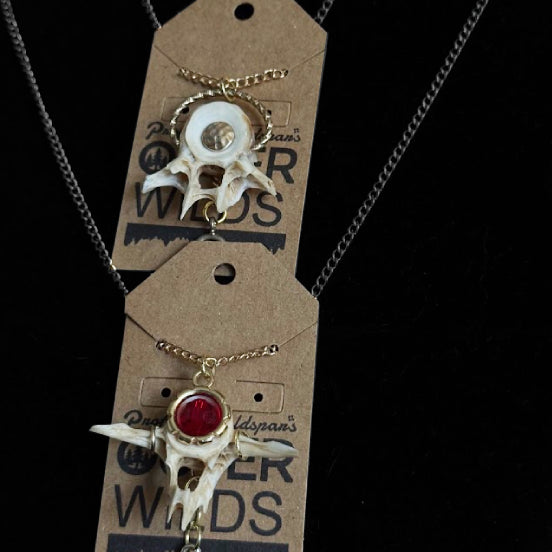 Necklace with fish vertebrae bone pendants on a branded card against a black background