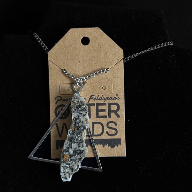 Necklace with a stone pendant (horsetooth calcite)  on a 'OUTER WILDS' branded tag against a black background