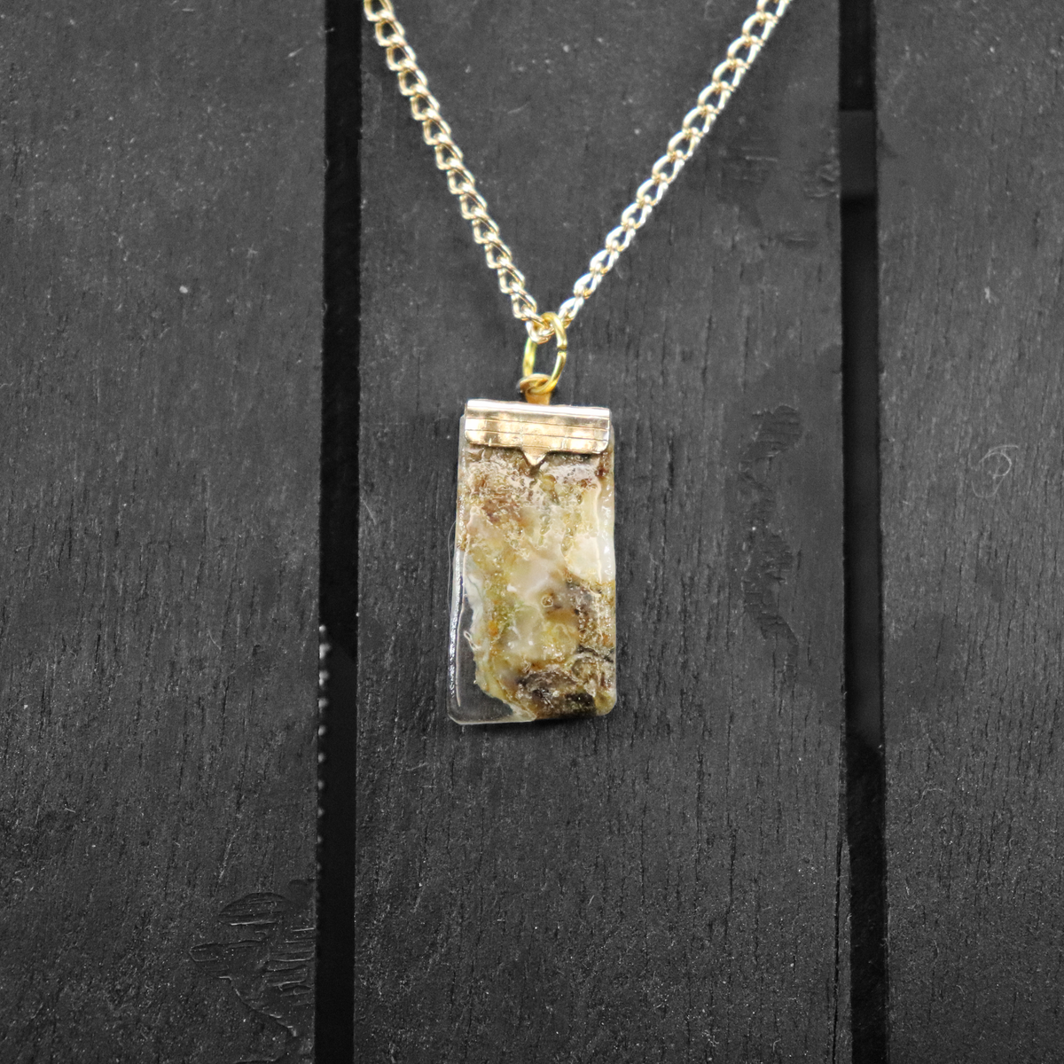 Necklace with a rectangular pendant on a dark wooden background